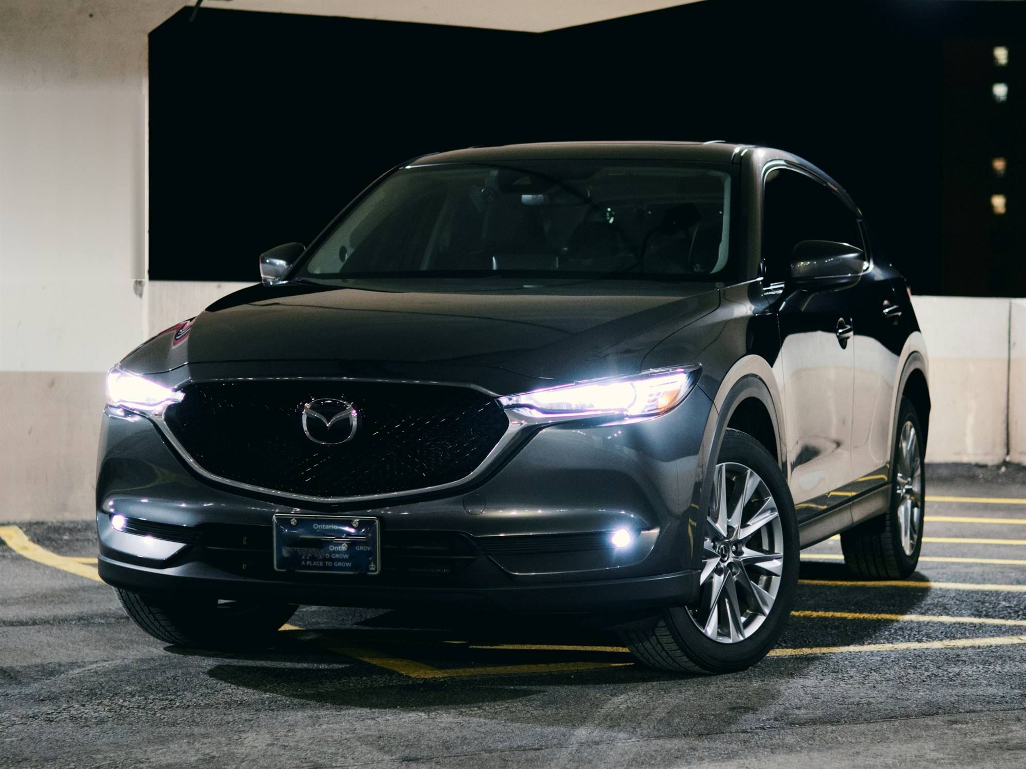 Un SUV Mazda CX-5 noir, phares allumés