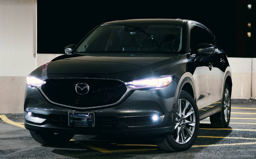 Un SUV Mazda CX-5 noir, phares allumés